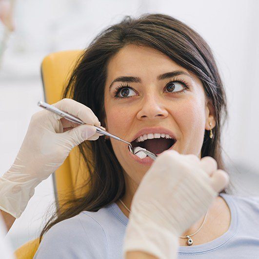 Dentist examining patient's smile after bone grafting procedure