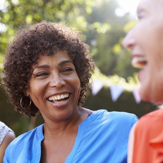 lady outside with perfect teeth smiling after dental implant tooth replacement