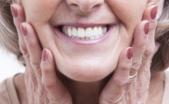 Woman showing off her new smile after dental implant tooth replacement