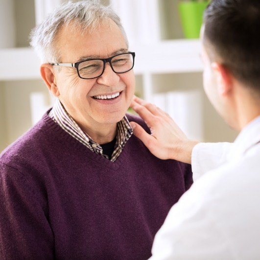 Older man smiling after dnetal implant salvage