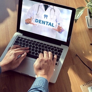 Man using computer to research dental insurance coverage