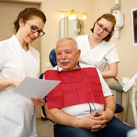 Patient and dental team discussing candidacy for dentures in Houston