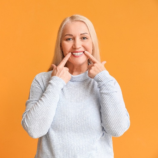 Mature woman pointing at her beautiful smile