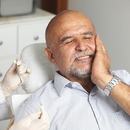 Pained man experiencing dental implant failure in Houston