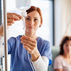 Oral surgery team member preparing IV drip for patient