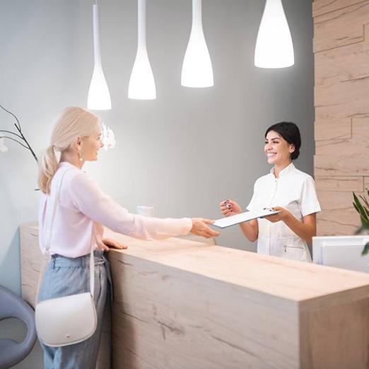 Dental patient accepting clipboard, learning about payment options