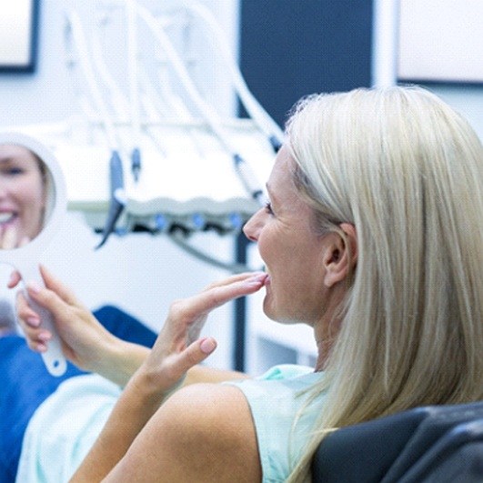Woman admiring the results of her Teeth in a Day treatment