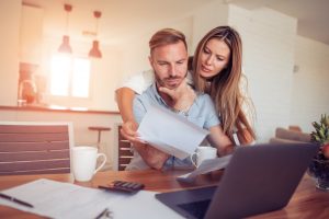 couple looking at paperwork and computer