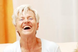 Smiling senior woman with dental implants in Houston