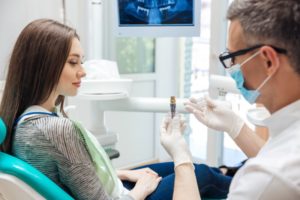Oral surgeon explaining dental implants 101 to curious patient
