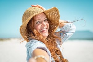 Woman at beach, enjoying summertime with dental implants