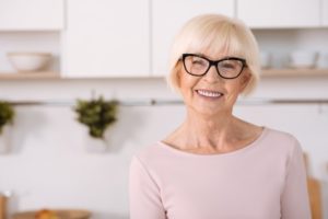 Senior woman happily adjusting to her implant dentures