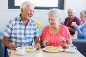 Senior couple enjoying a meal, eating with dentures