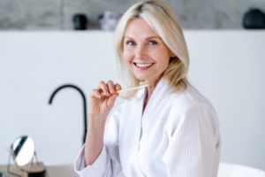Smiling middle-aged woman holding toothbrush